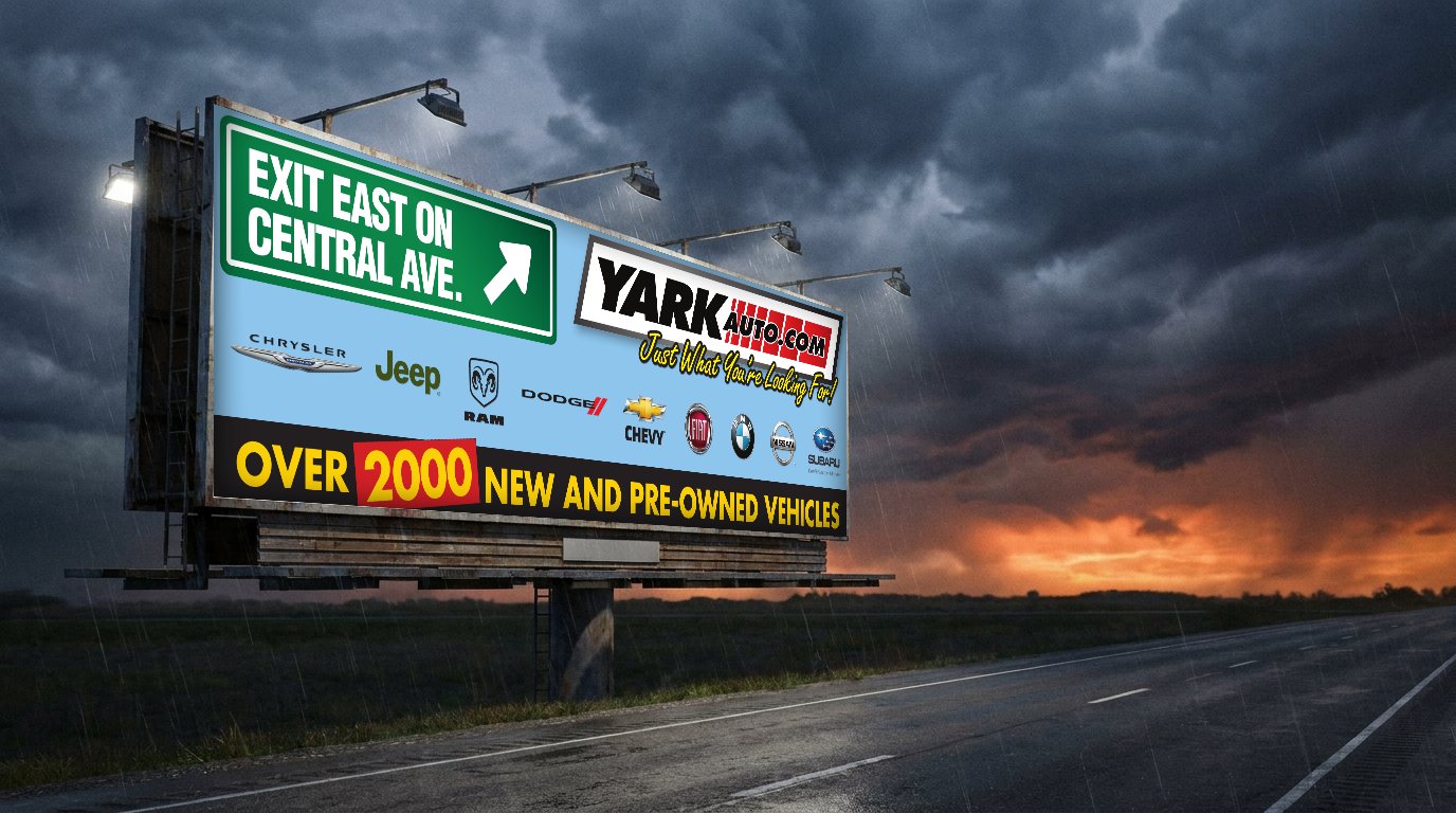 Yark Auto billboard on a highway under storm clouds